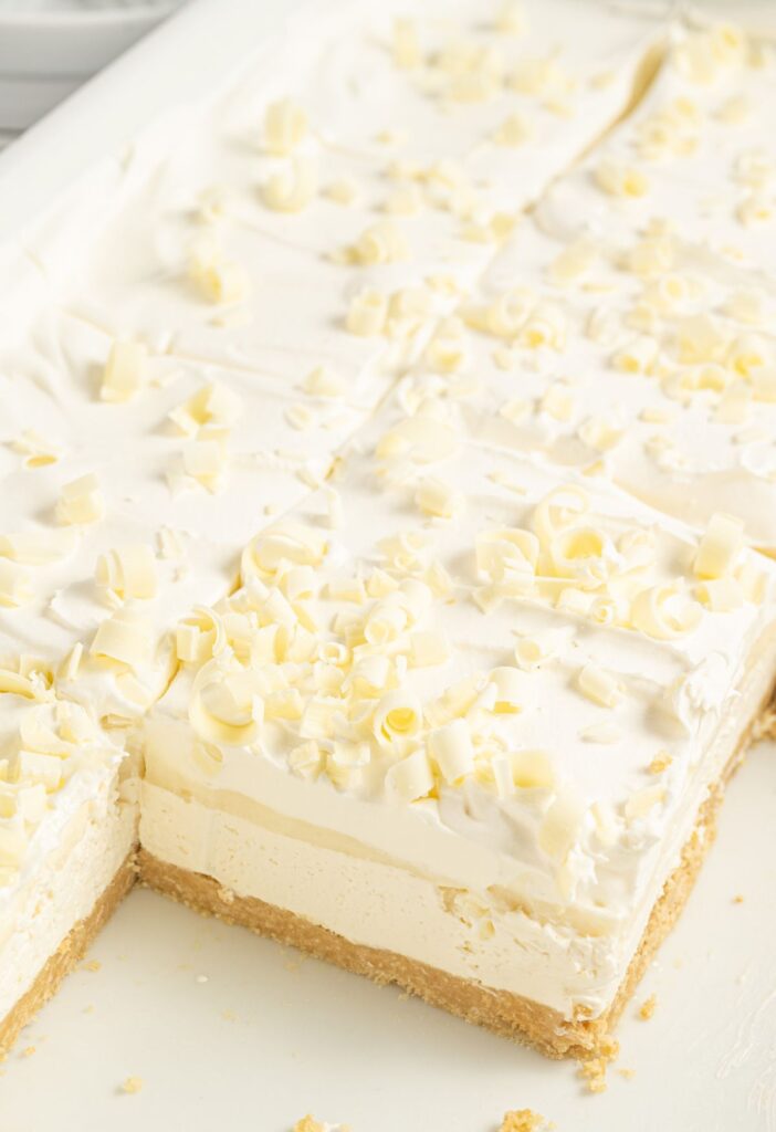 A layered lasagna dessert with white chocolate curls on top. 