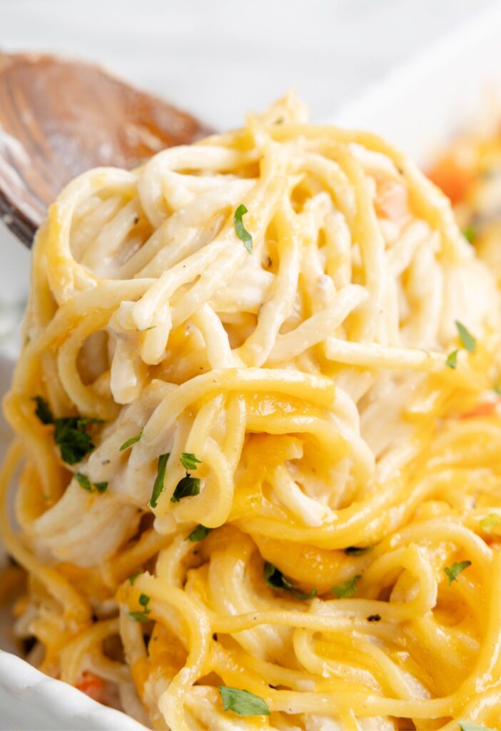 A serving spoon of cheesy spaghetti 