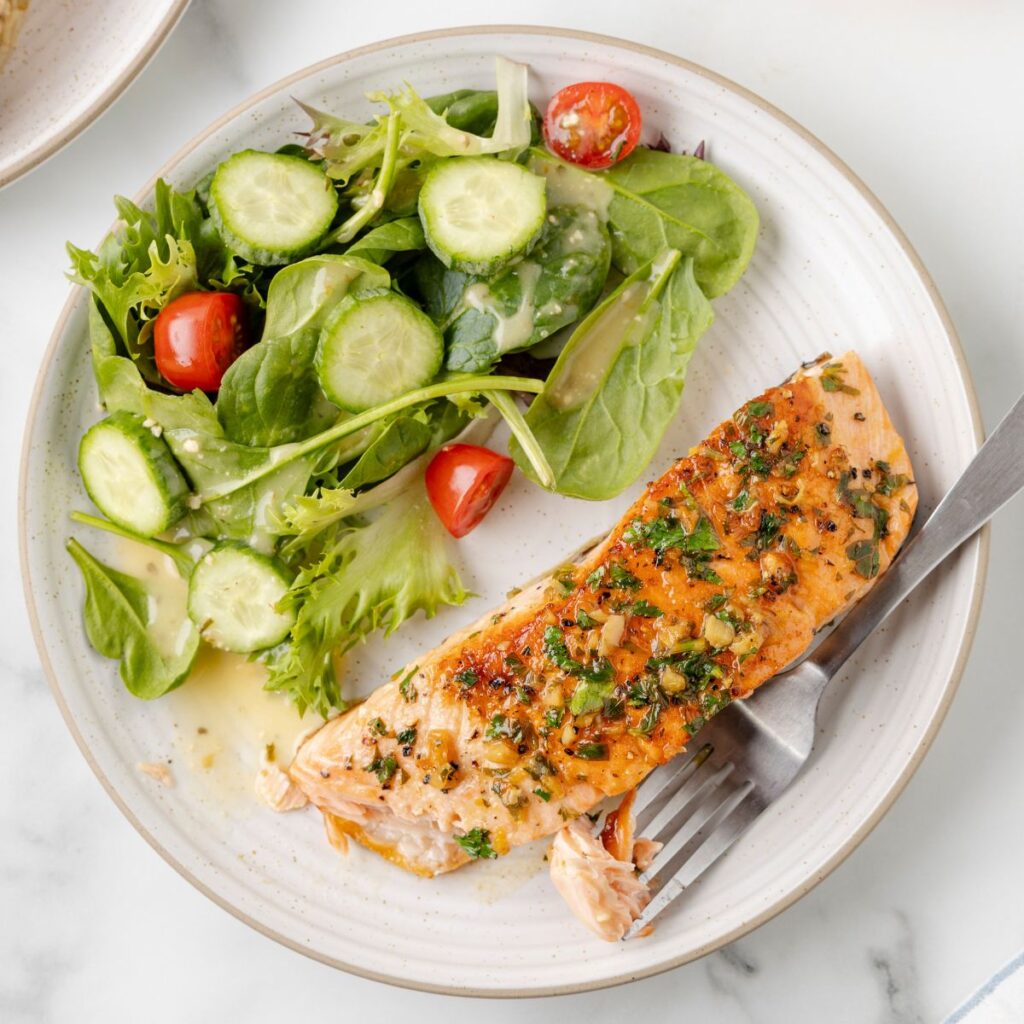 A plate of salmon and green salad