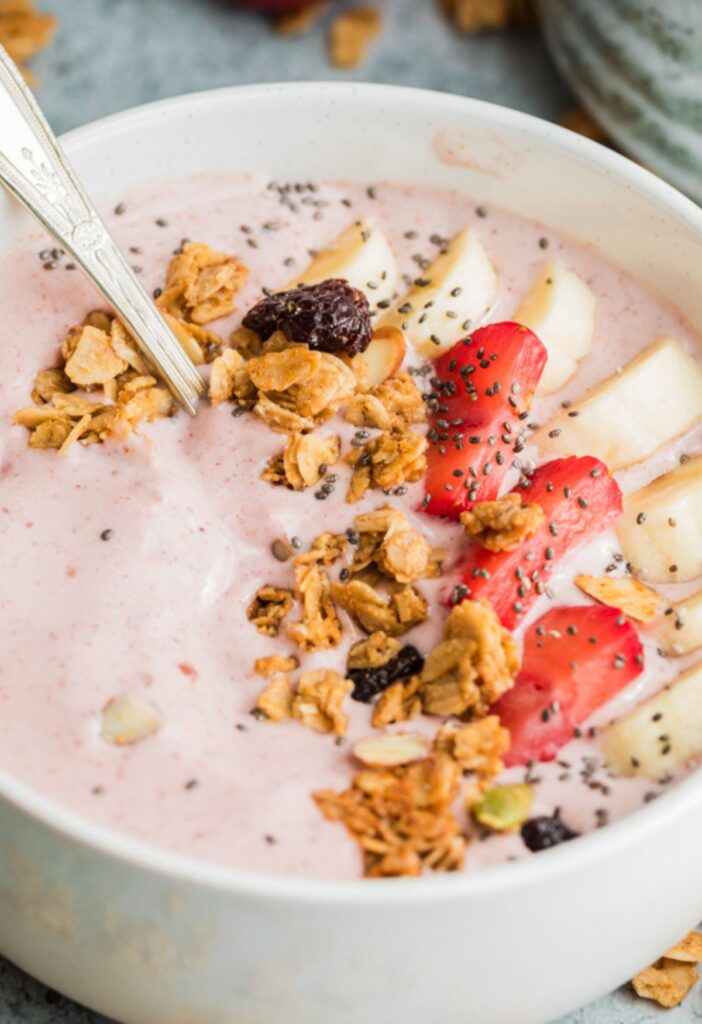 A smoothie bowl with a spoon inside of it. 