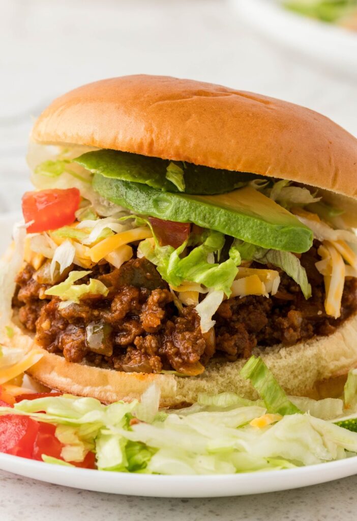 A sloppy Joe in a bun with toppings.