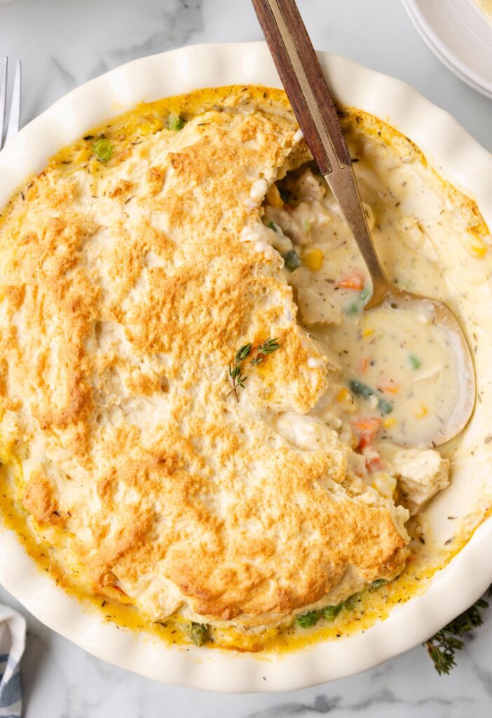 Hero shot of the baked pot pie with a piece cut out to show the creamy sauce. 