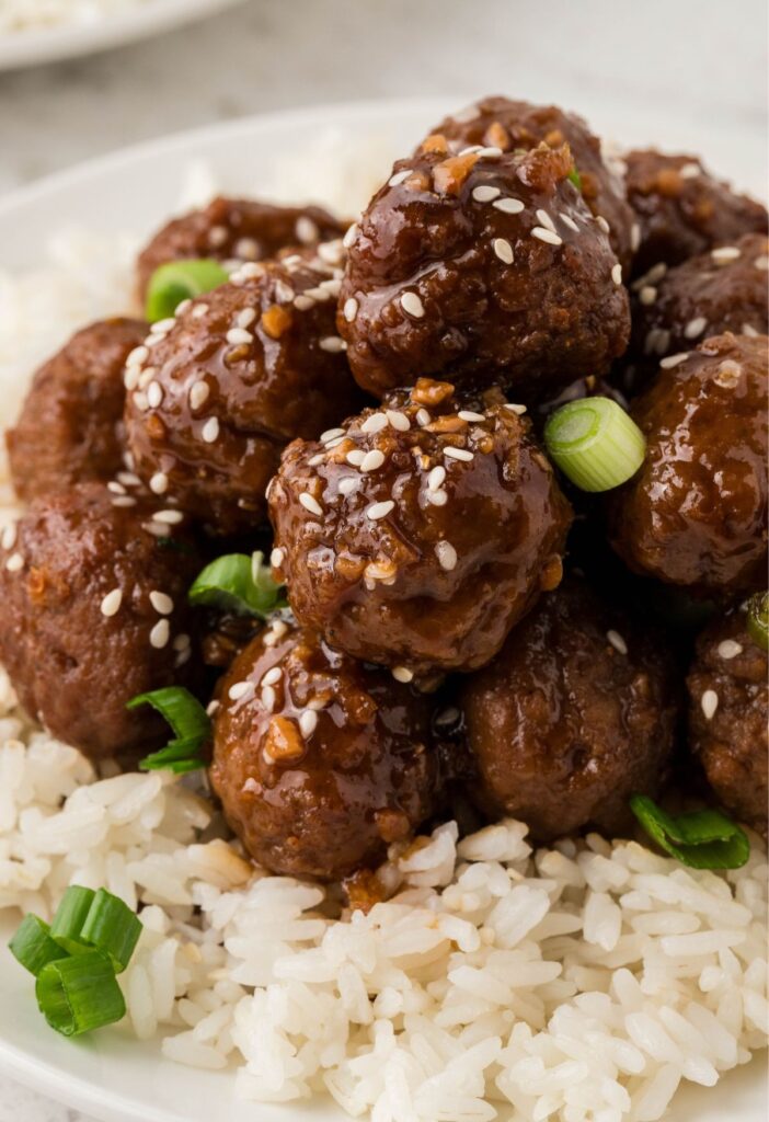 Meatballs over white rice with green onions