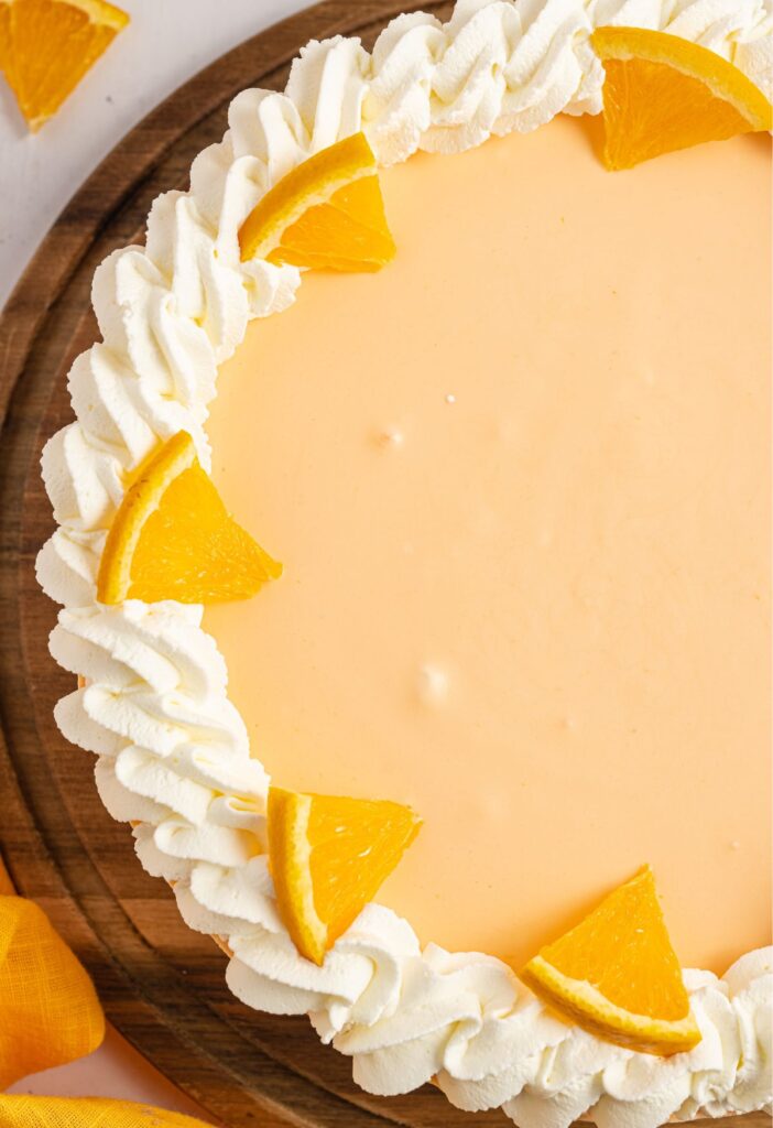 A orange cheesecake with whipped cream garnish 