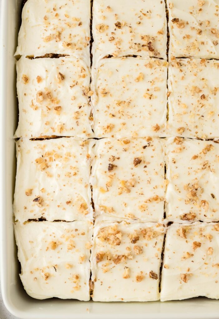 A pan of the cake frosted and topped with walnuts. 