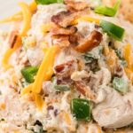 A chicken salad scoop on top of lettuce greens