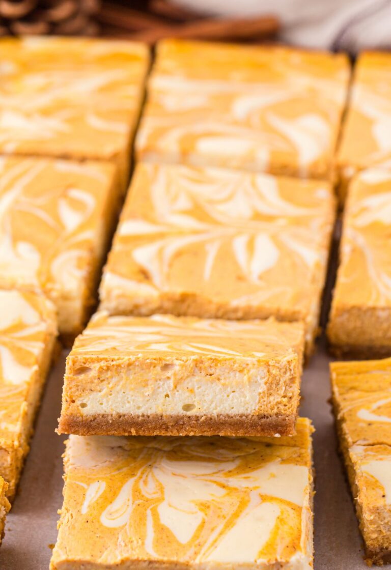 A row of cheesecake bars with one tilted up to see the middle.