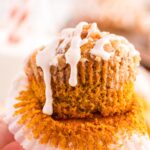 A hand holding a pumpkin muffin