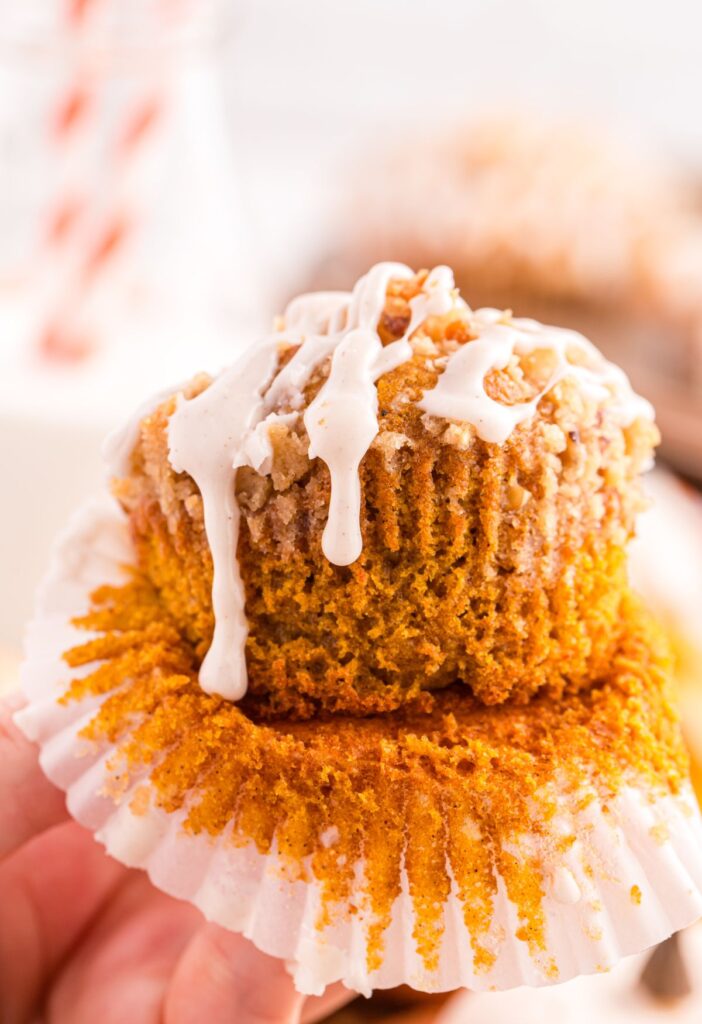 A hand holding a pumpkin muffin