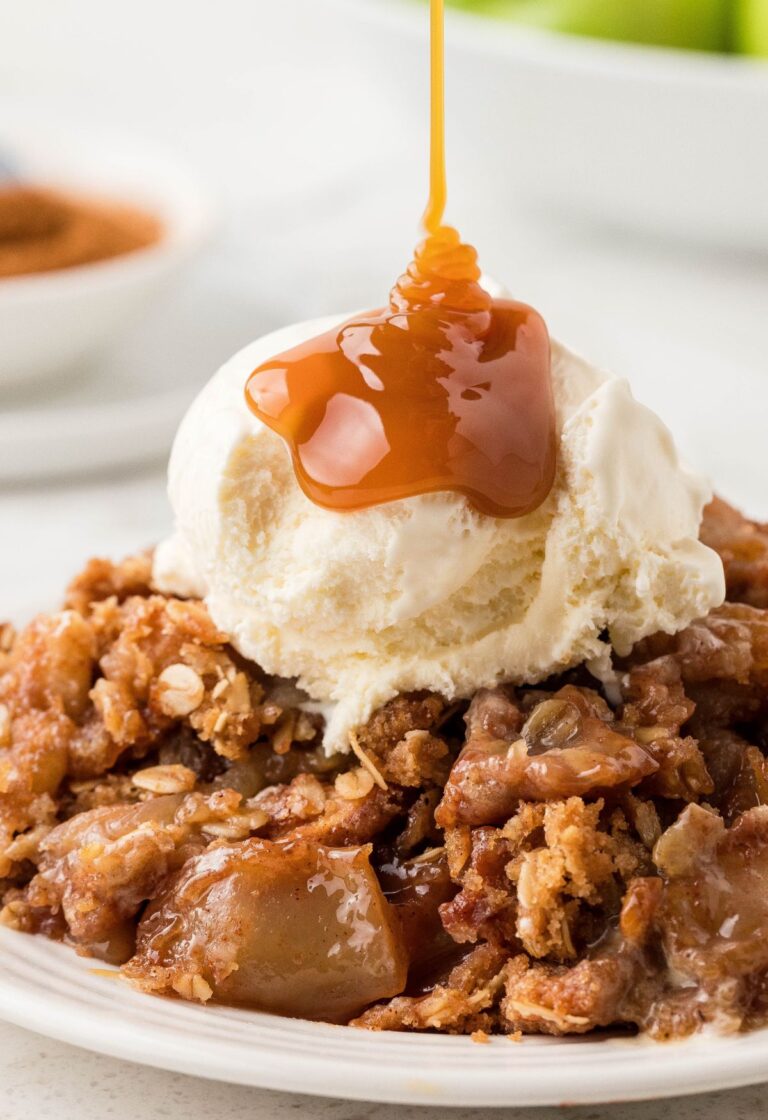 Apple fruit crisp with ice cream and a caramel drizzle coming over top