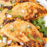 Crispy tacos close up pic with cilantro and black beans.