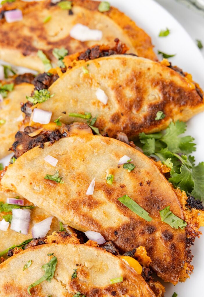 Crispy tacos close up pic with cilantro and black beans. 