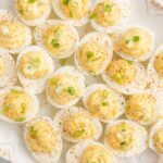 Platter of deviled eggs with cajun seasoning and ingredients