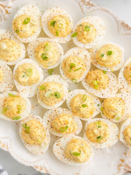 Platter of deviled eggs with cajun seasoning and ingredients