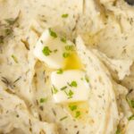 Inside of the slow cooker with mashed potato and butter.