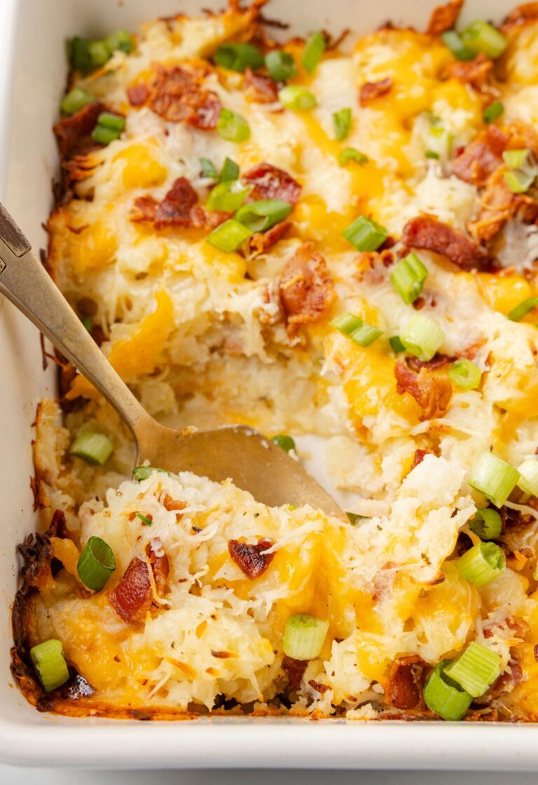 A baking dish with potato casserole and a serving spoon