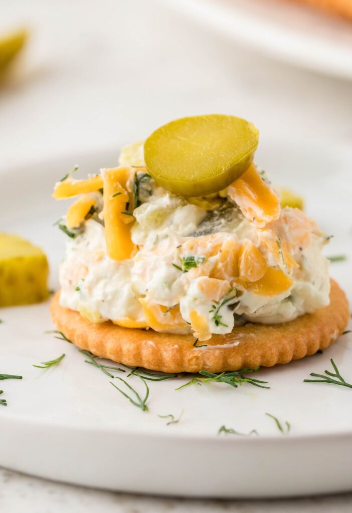A cracker with a pile of cheeseball on it for serving.