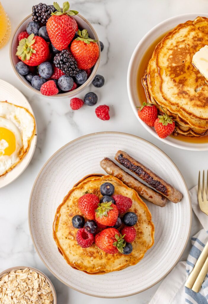 Serving of the pancakes on a plate with sausage and eggs