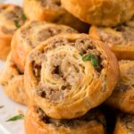 Sausage pinwheels stacked on a white plate