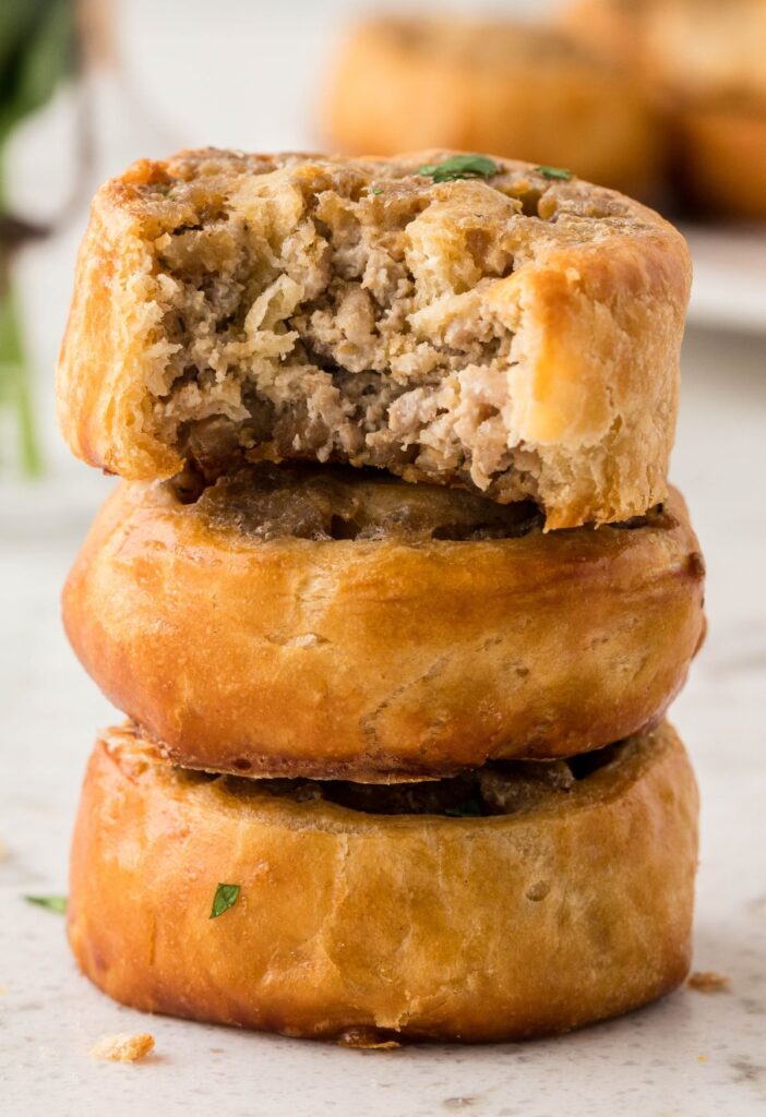 Stack of sausage pinwheels with a bite taken out of the top one. 