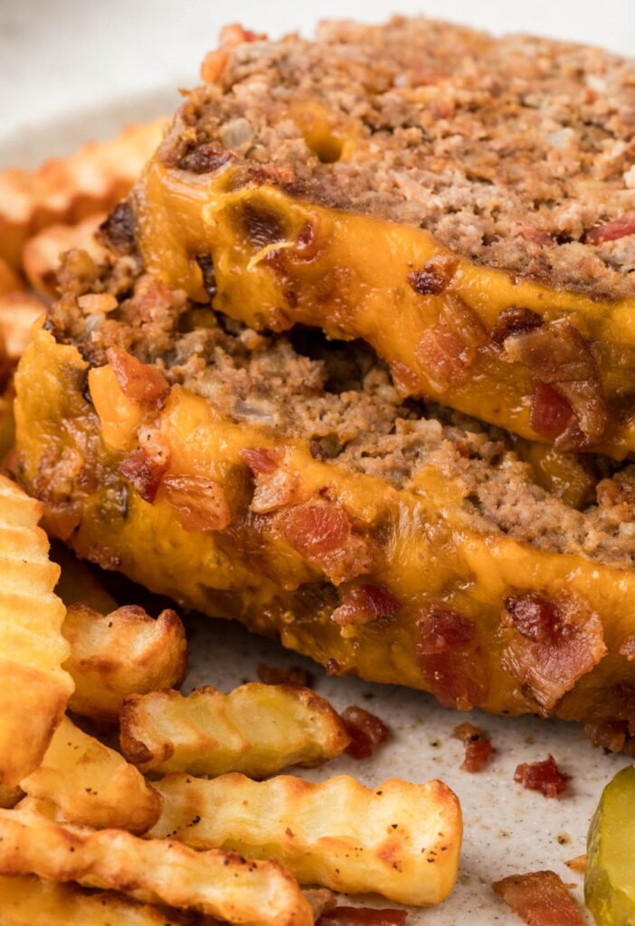 Sliced meatloaf on a plate with fries next to it