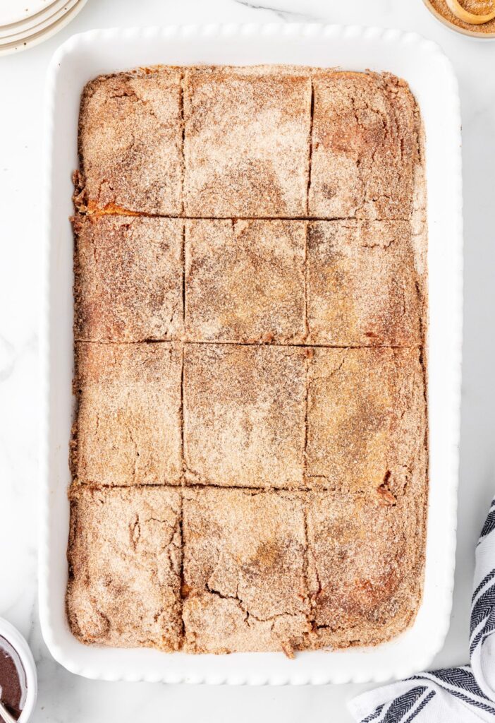 Overhead pic of the pan of cheesecake bars with cinnamon sugar on top