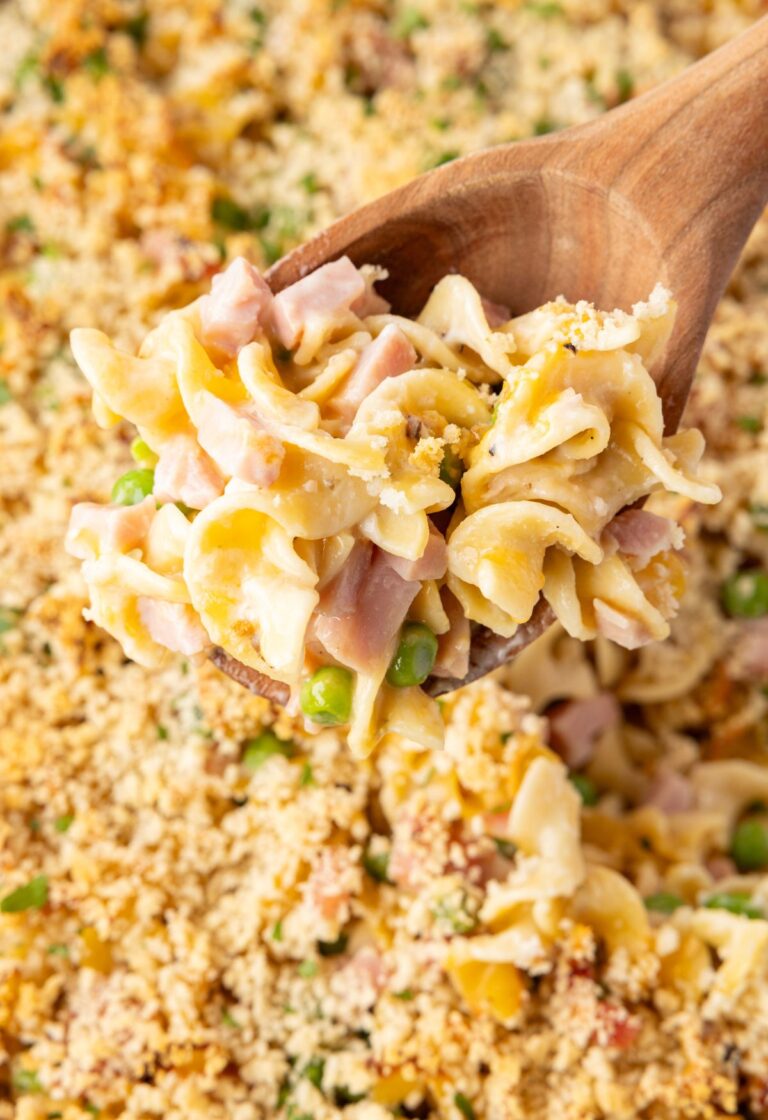 A close up of the serving spoon with some ham casserole on it.
