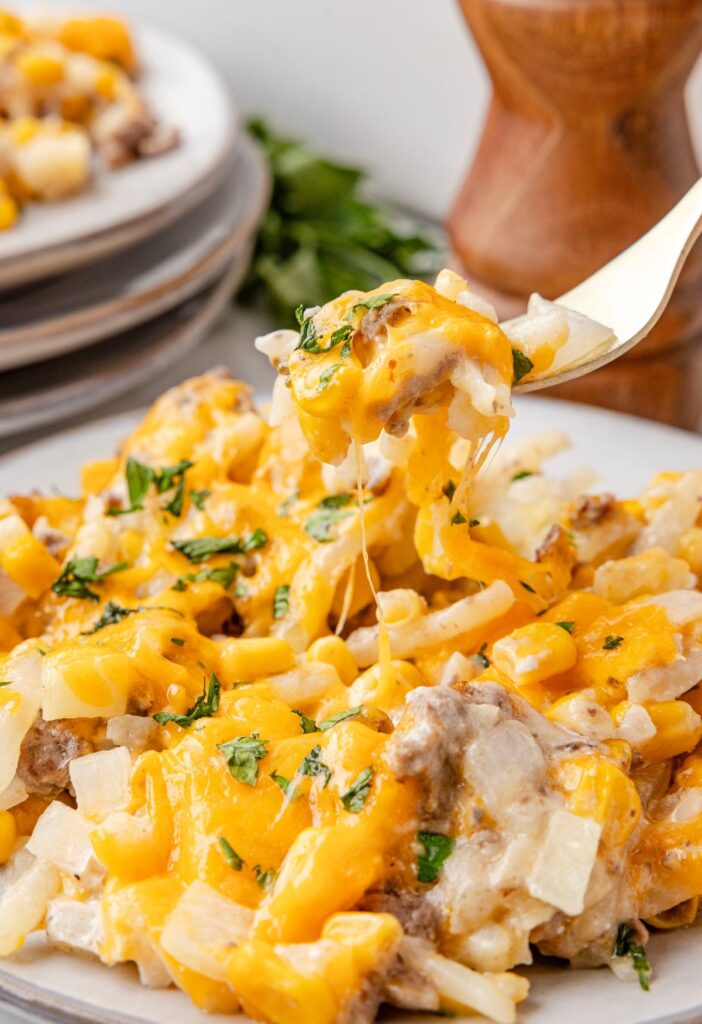 A fork with a bite of the ground beef casserole on it