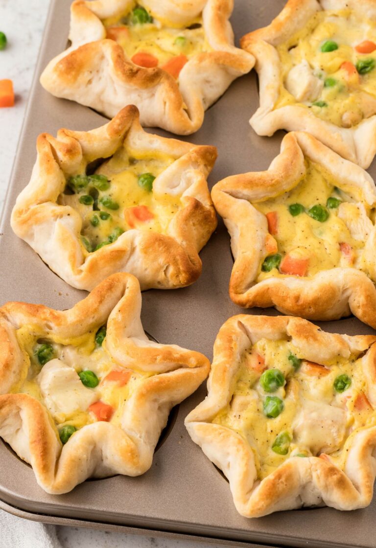A muffin pan with biscuit mini pies with chicken
