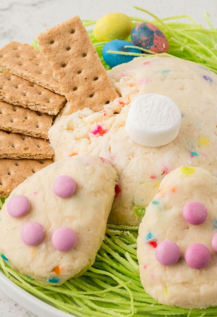 Hero shot of the easter cheeseball recipe with a graham cracker being dipped in it. 
