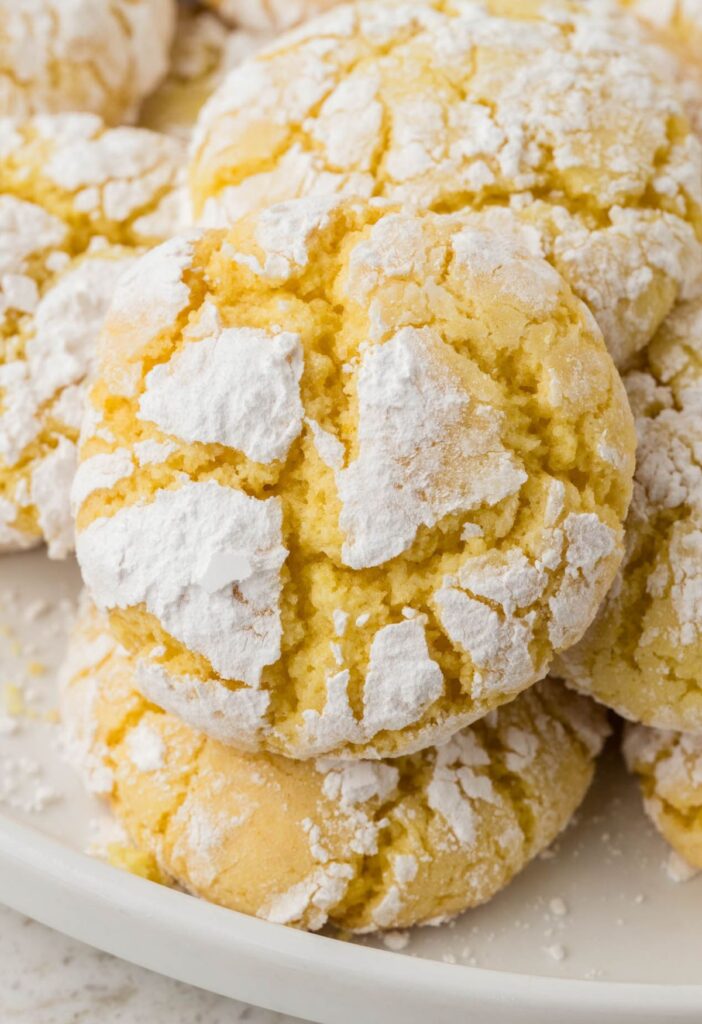 A white plate with several lemon cookies on it