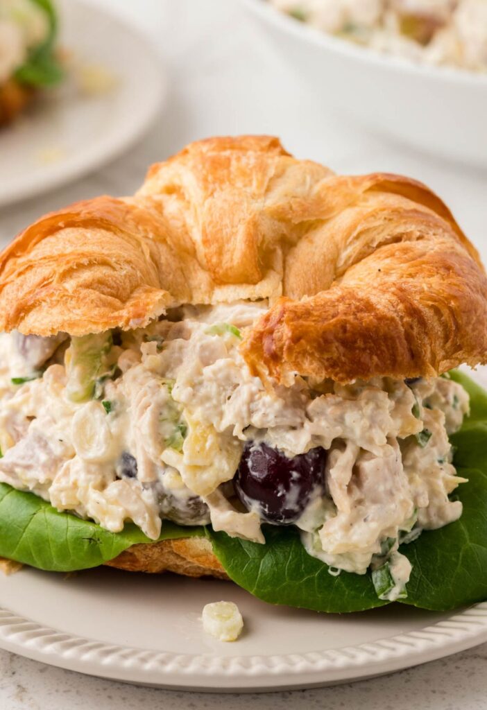 A croissant sandwich with pineapple chicken salad in it. 