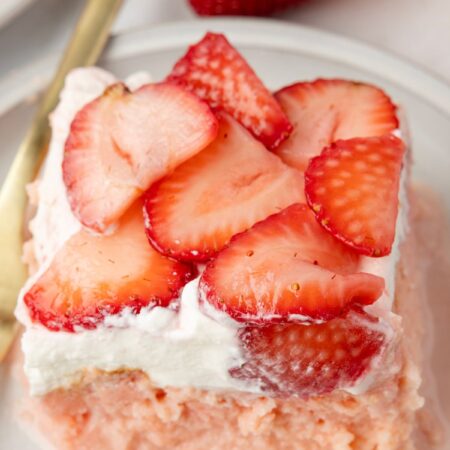 A slice of tres leches cake with strawberries on top