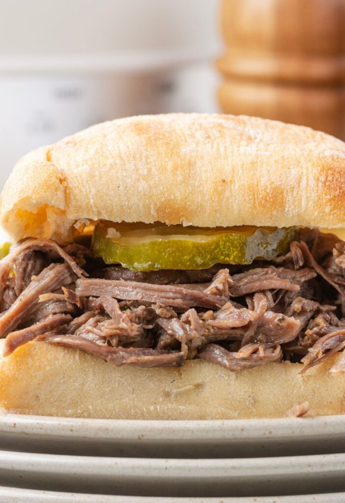 Sandwich with shredded beef and a pickles inside of it
