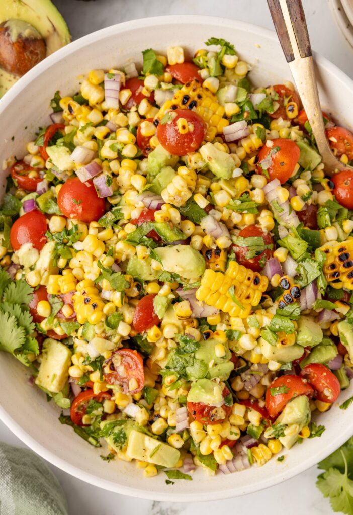 Top view of the salad with avocado, corn, red onion, and dressing