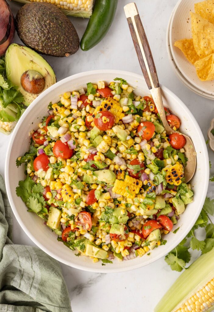 Corn salad in the bowl with a serving spoon