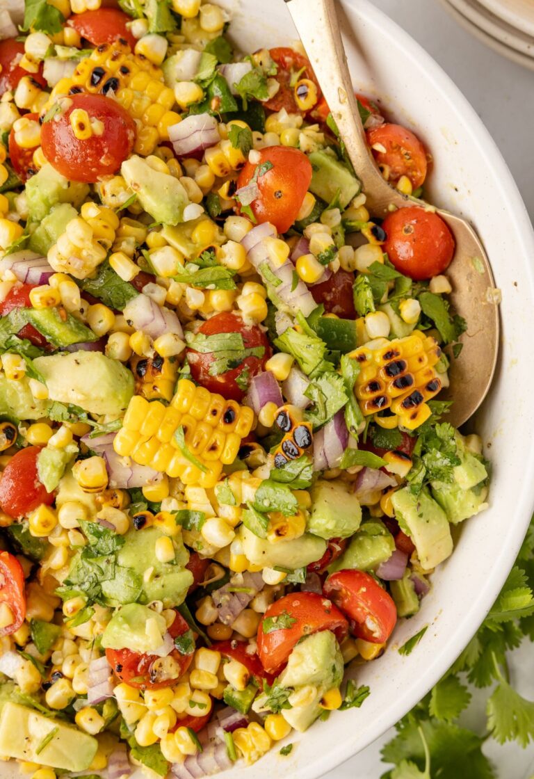 A serving bowl of the charred corn and avocado salad