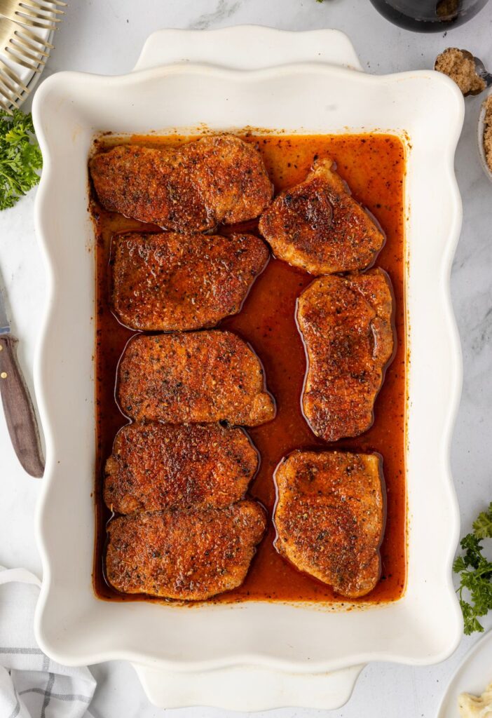 A casserole dish with the baked pork chops in it
