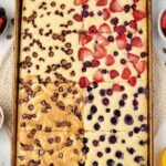 Sheet pan with the pancakes on it with different toppings on each part.