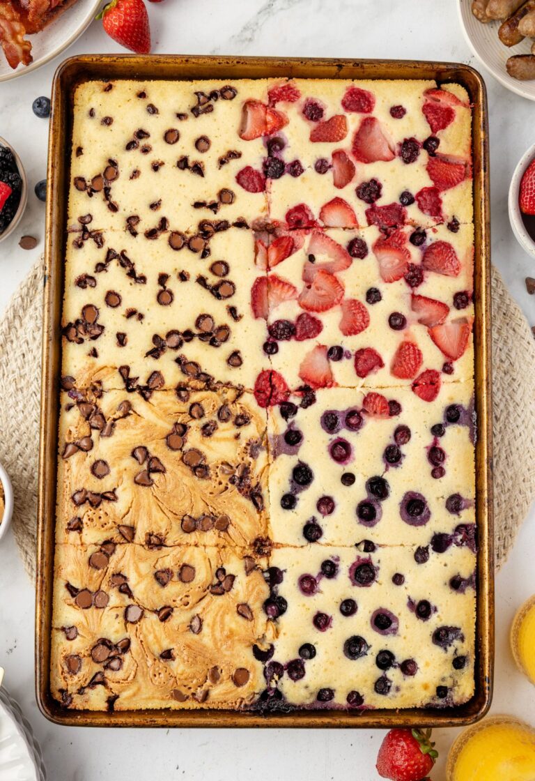 Sheet pan with the pancakes on it with different toppings on each part.