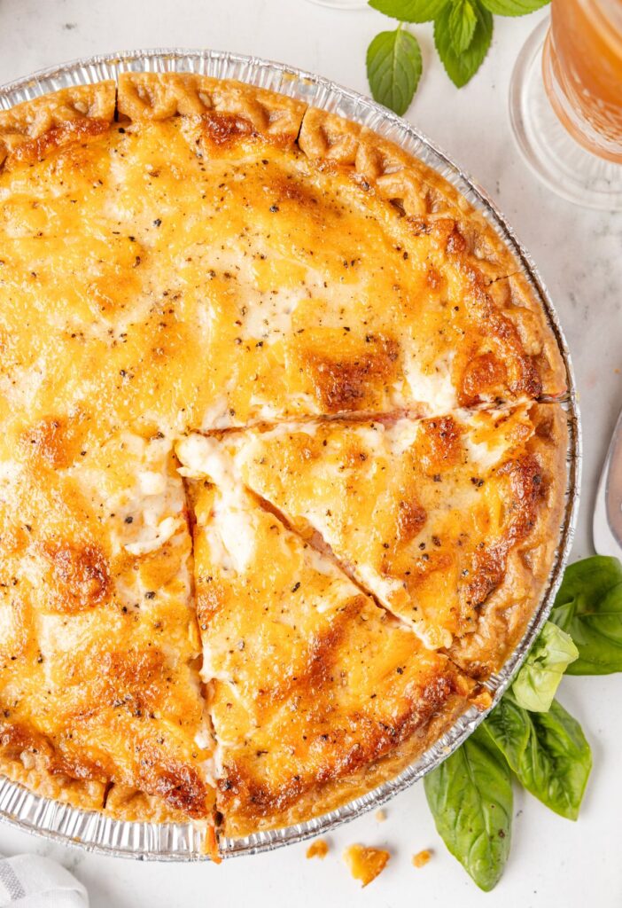 A baked tomato pie with slices cut into the pie