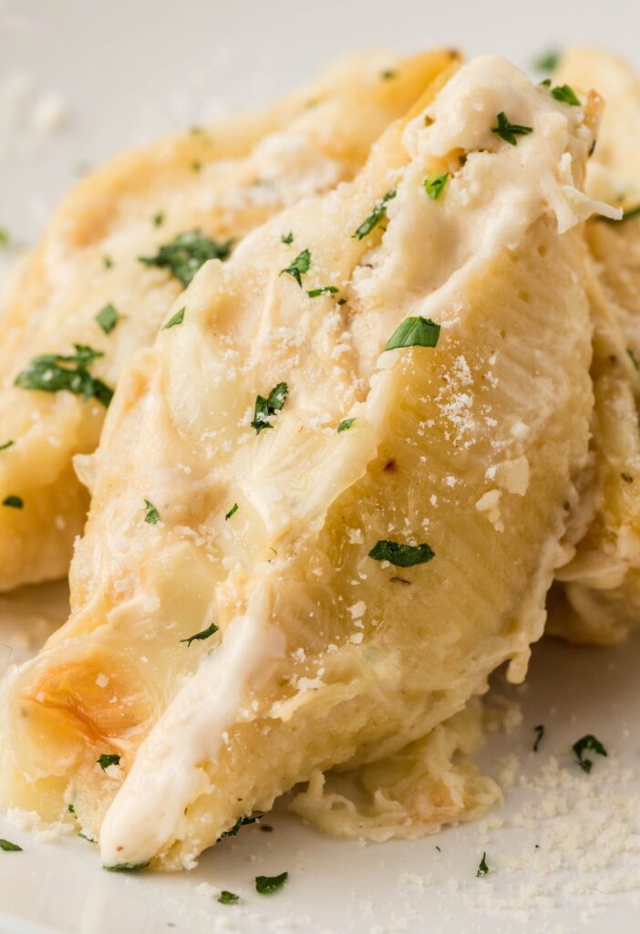 One stuffed shell on a white serving plate
