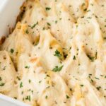 Stuffed shells inside a white casserole pan.