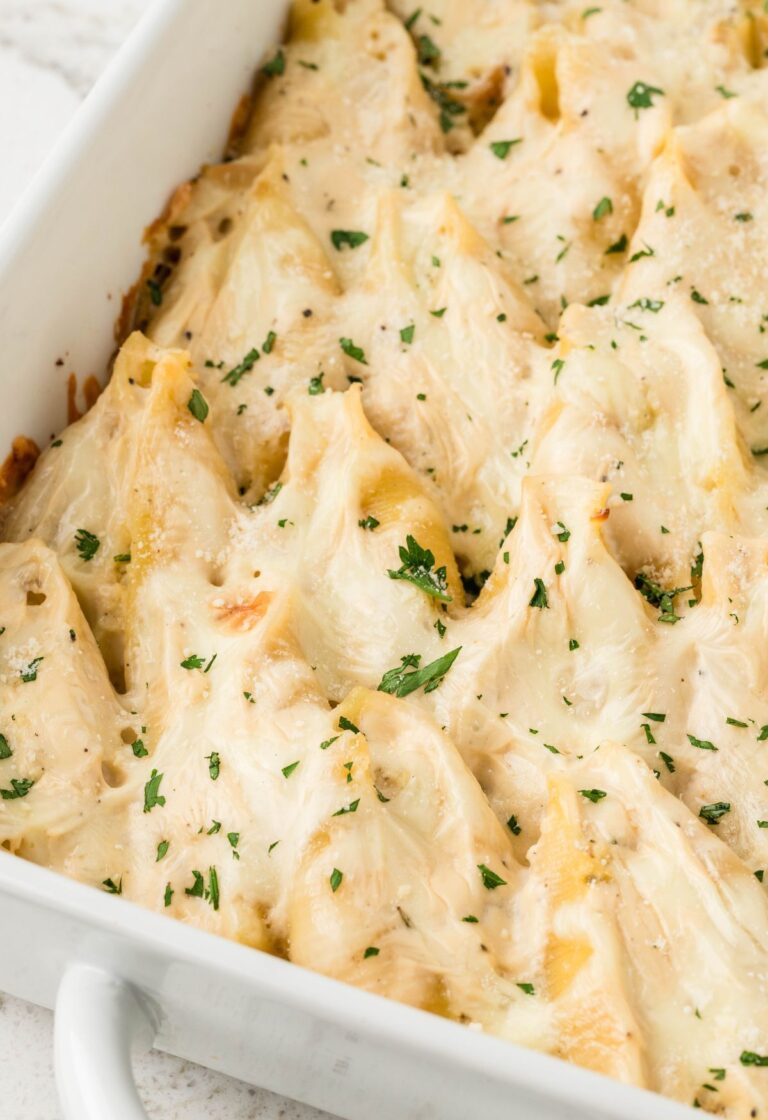 Stuffed shells inside a white casserole pan.