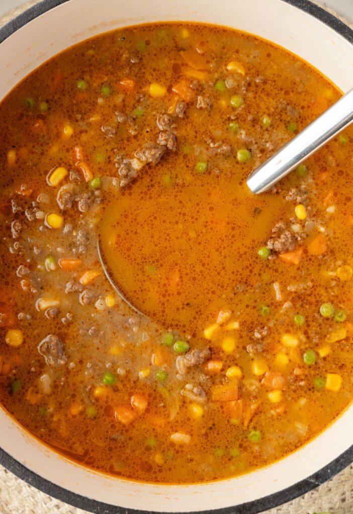 A soup pot of shepherds pie soup with a soup ladle in it. 