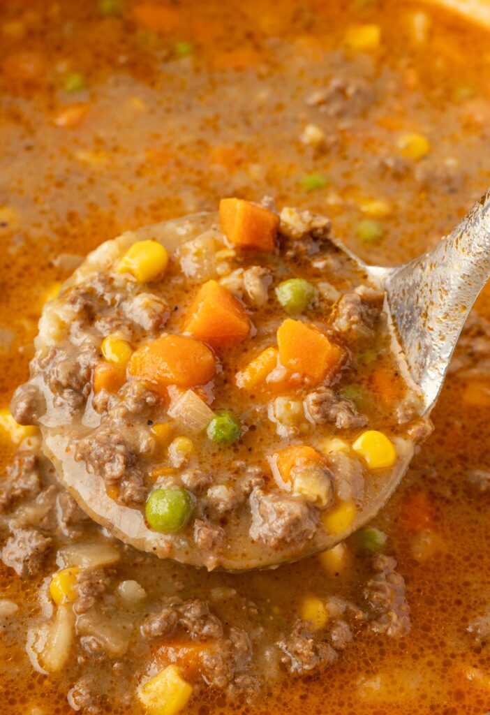 A close up image of the soup inside a soup ladle