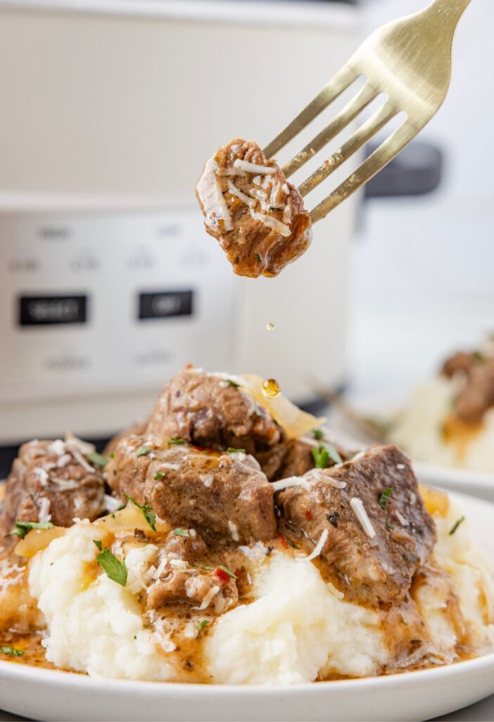 A fork with a steak bite on it