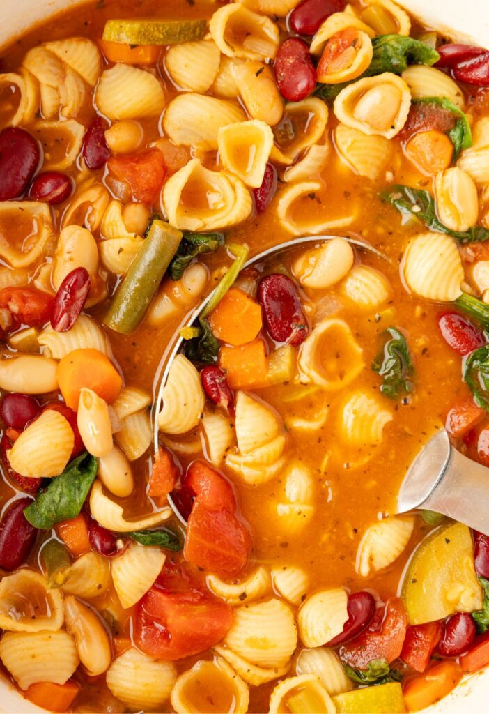 Pot of soup with a soup ladle inside of it.