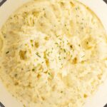 Top view of inside the pot with the mashed potatoes in it topped with fresh chives