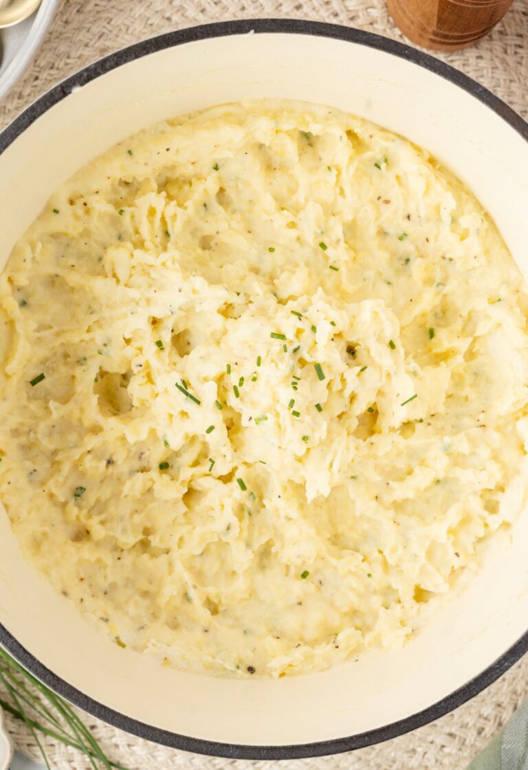 Top view of inside the pot with the mashed potatoes in it topped with fresh chives